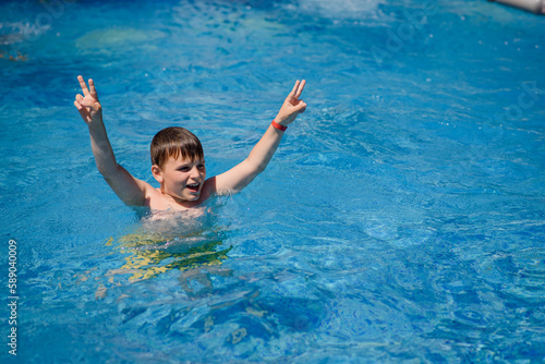 boy is swimming and having fun in the swimming pool..