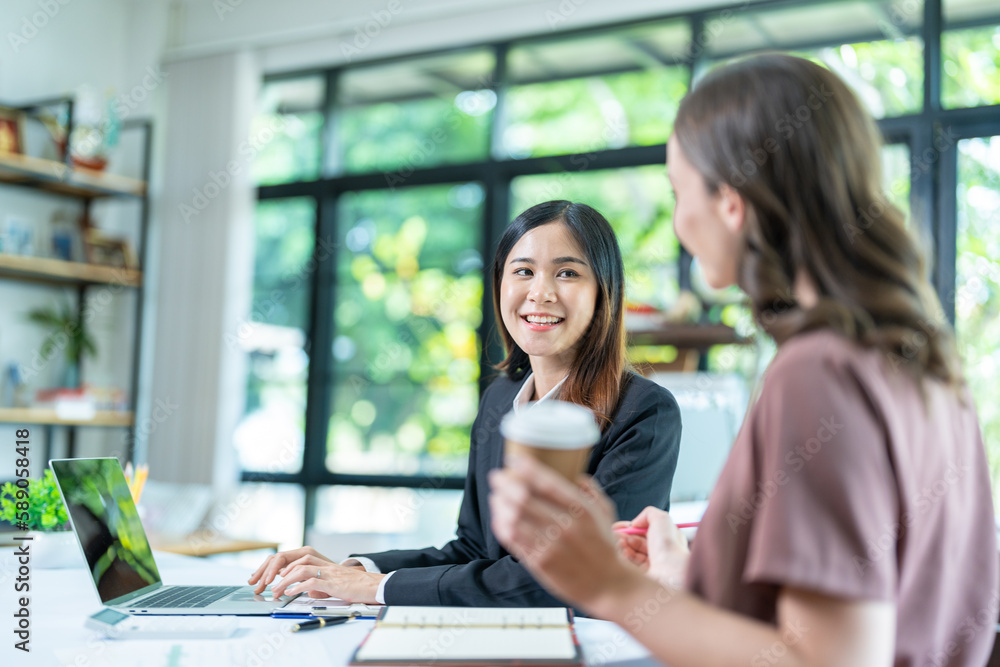 Smiling businesswoman working together on contract document, happy colleague meeting for planning new project in office Smiling businesswoman working together on contract document, happy colleague meeting for planning new project in office