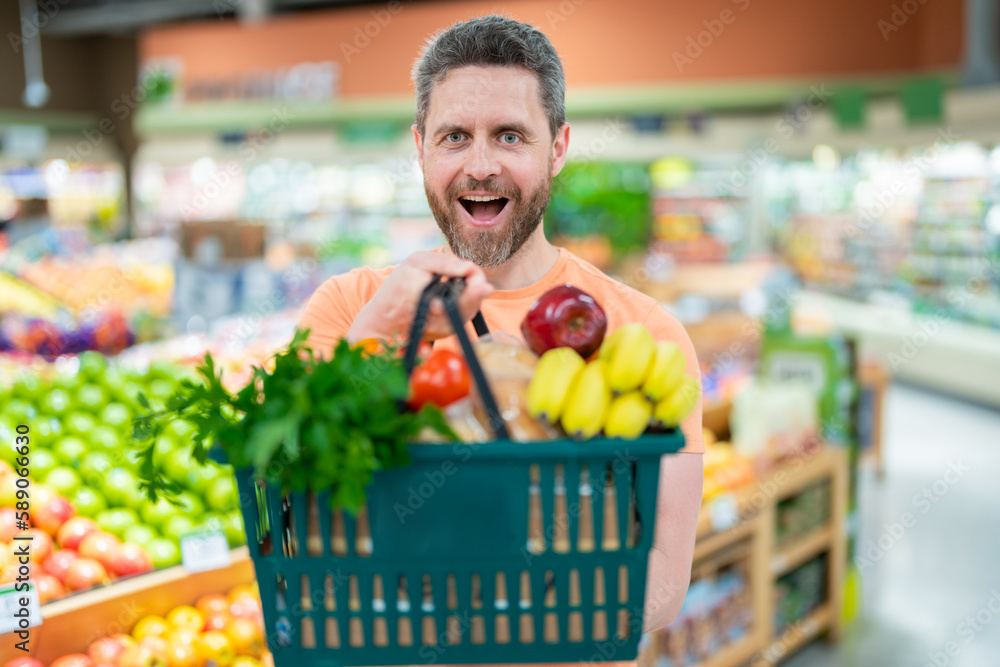 Man with shopping basket full of vegetables and fruits. Middle aged ...