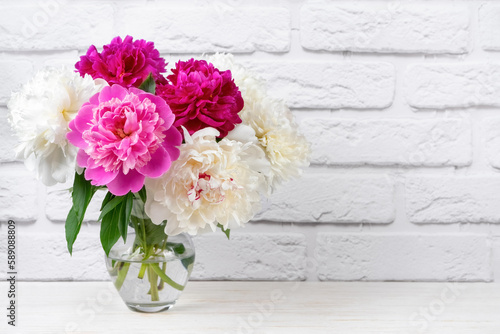 Bouquet of pink and white peony flowers in vase on white brick wall background. Mockup, template for holiday, birthday, mother's day. Banner, header with copy space