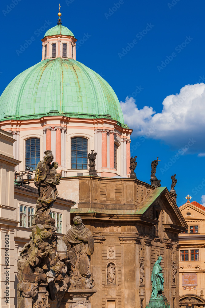 Baroque St. Francis Of Assisi Church with Charles Bridge Virgin Mary statue and King Charles IV monument in Prague