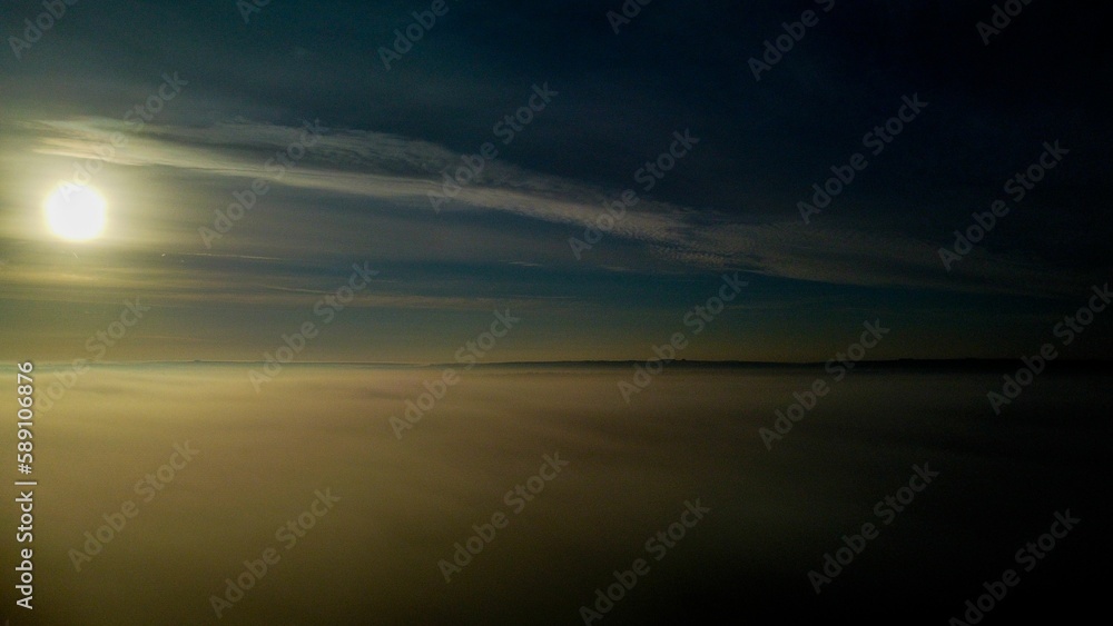 Fototapeta premium Long-exposure aerial view of a steam-covered seascape at sunset