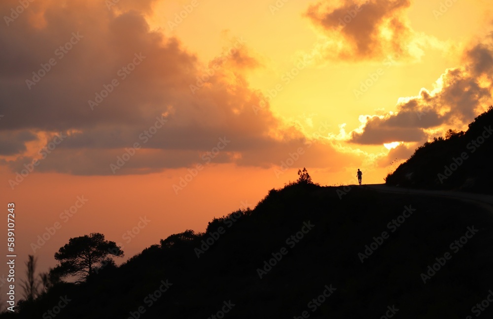 View of a person at sunset along the top of the road on the Carmel mountain, Haifa, Israel