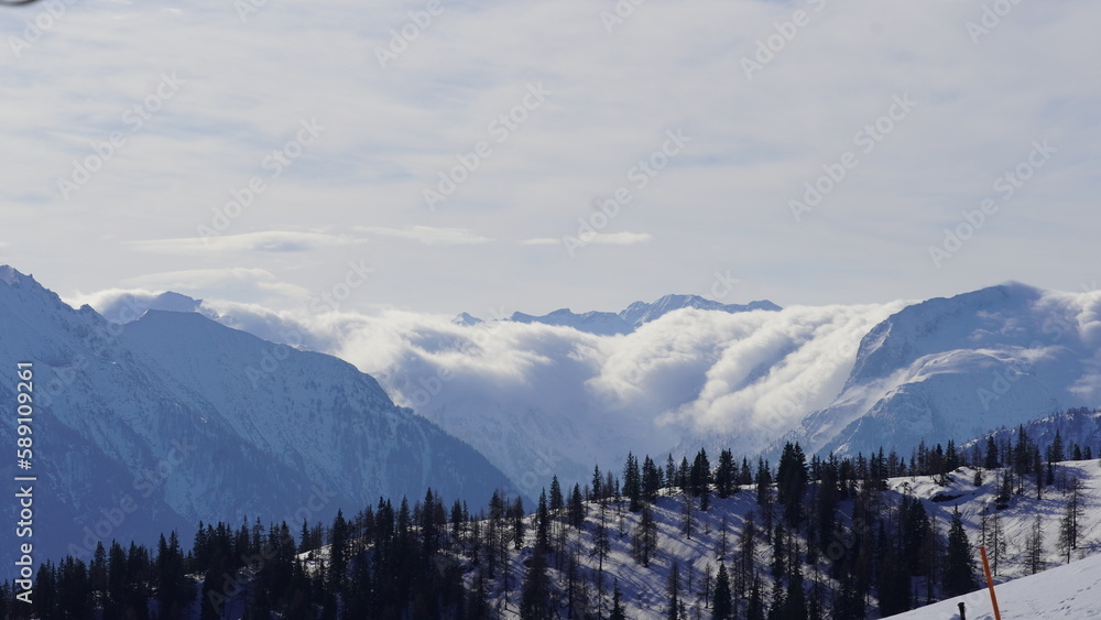 Wolken kriechen über beschneiten Berg 