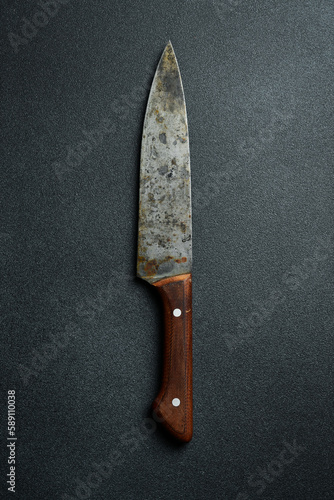 Vintage old metal knife. Top view. On a dark gray background.