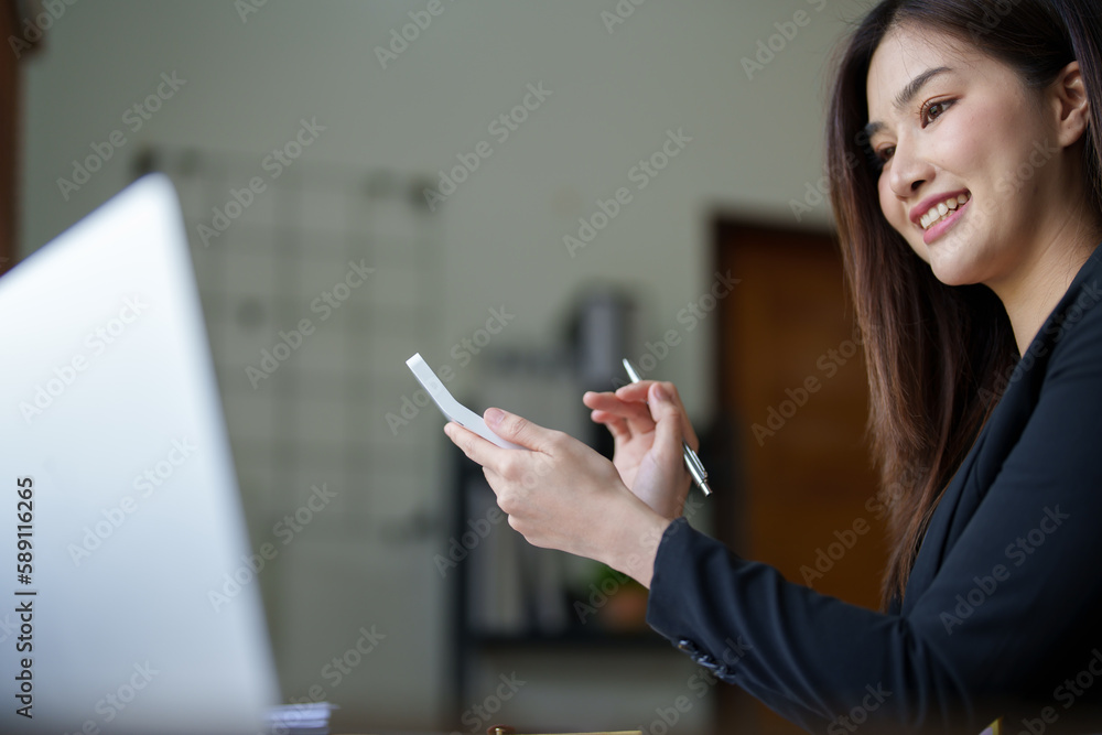 businesswoman or accountant working on calculator and laptop computer to calculate business data during using accountancy document at office businesswoman or accountant working on calculator and laptop computer to calculate business data during using accountancy document at office
