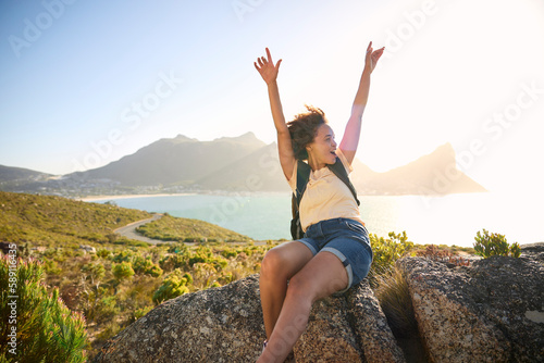 Portrait Of Woman With Backpack On Vacation Taking A Break On Hike By Sea Stretching Arms In The Air