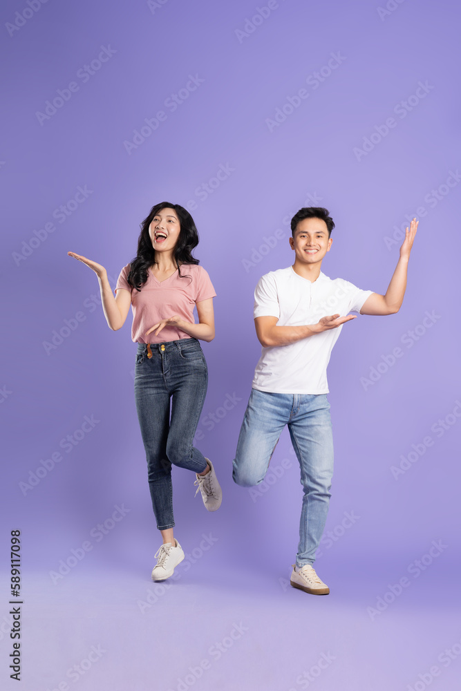 Fototapeta premium full body image of asian couple posing on purple background