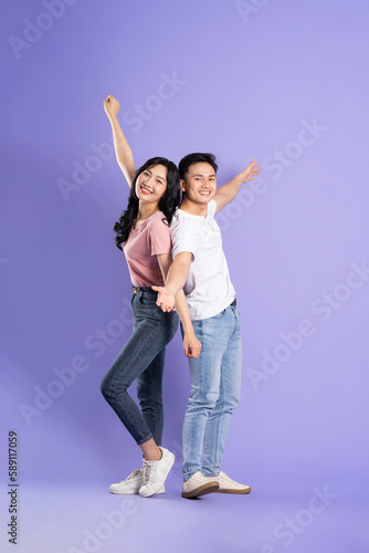 full body image of asian couple posing on purple background