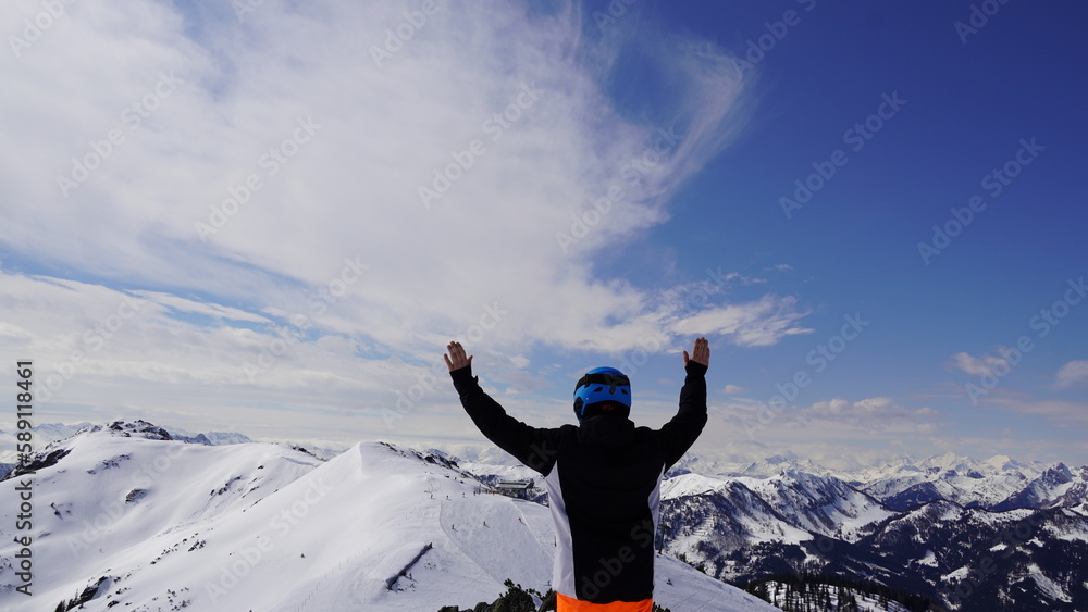 Person auf Bergspitze mit Gipfelkreuzt 