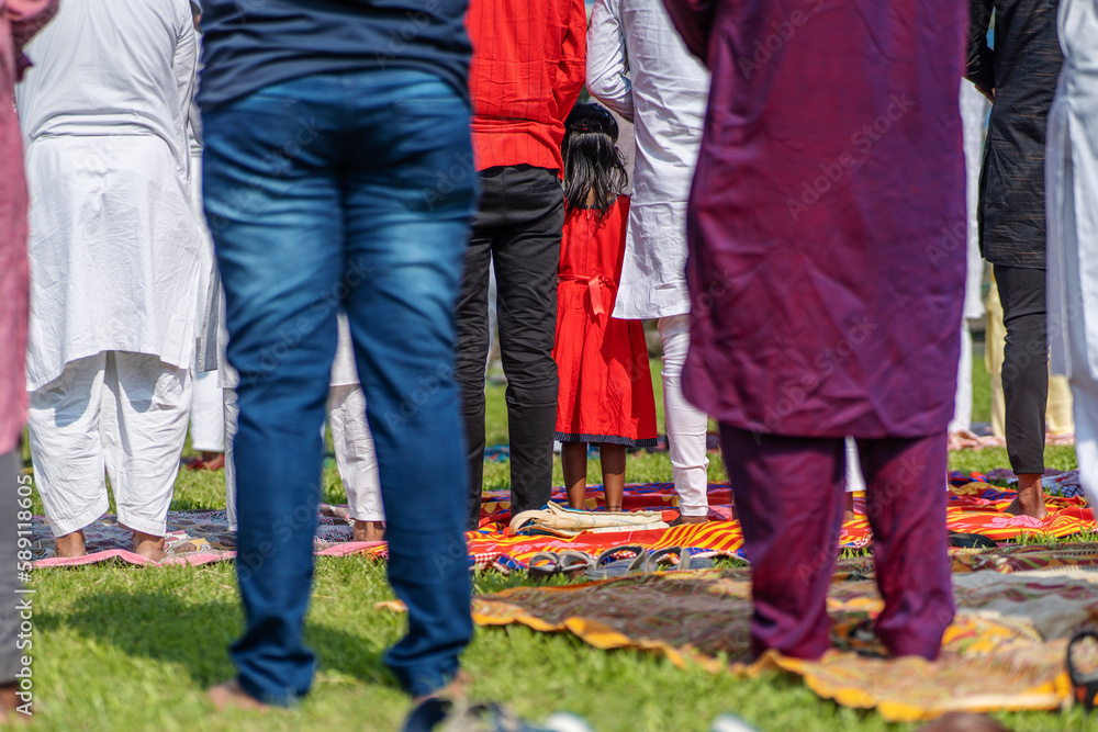 Kid standing in between people offering Ramadan prayers praying to Allah Kid standing in between people offering Ramadan prayers praying to Allah