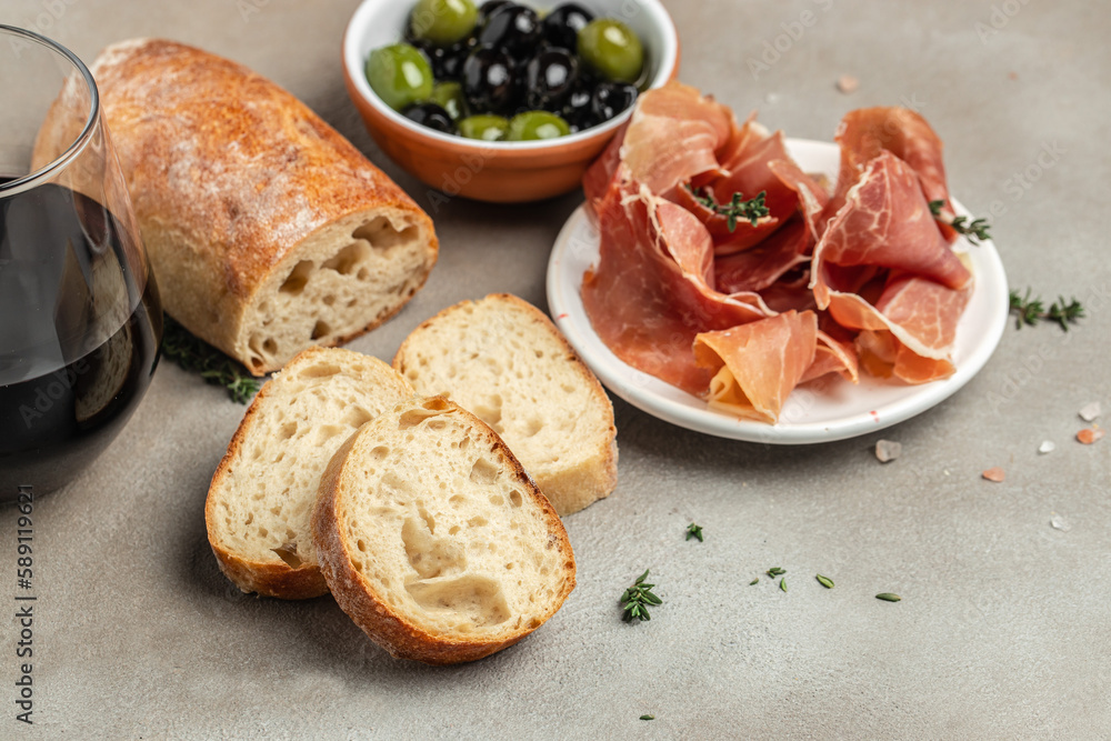 Bread ciabatta, jamon ham serrano paleta iberica, olives and glass of red wine, Tapas, antipasti. top view Bread ciabatta, jamon ham serrano paleta iberica, olives and glass of red wine, Tapas, antipasti. top view