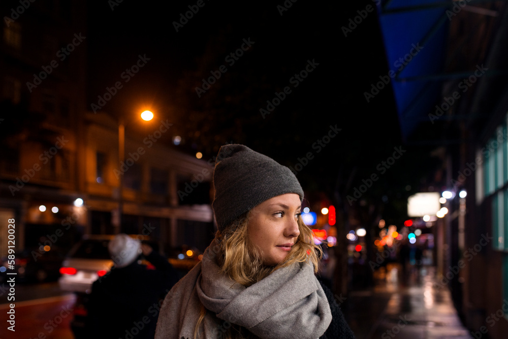 Woman standing in city at night