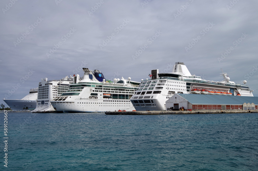 Modern cruiseship cruise ship liners Epic, Enchantment and Symphony  line up in port of Nassau, Bahamas during mass transportation Caribbean cruising holiday vacation in summer	