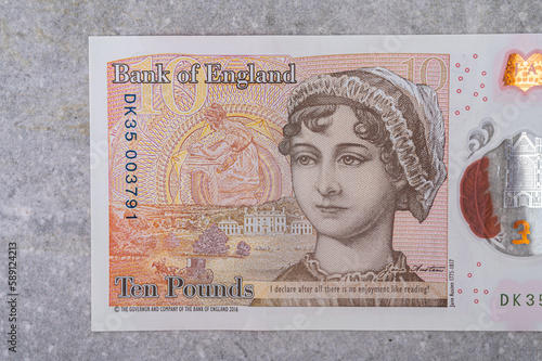 Banknotes in denominations of 10 with the image of a portrait of Jane Austen on a gray background photo