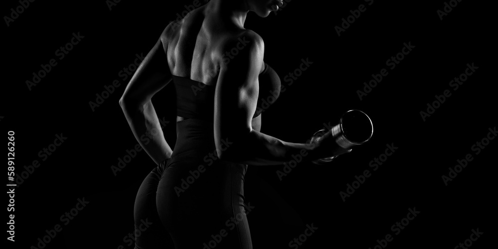 Black and white image of a sports girl on a black background. Fitness concept.