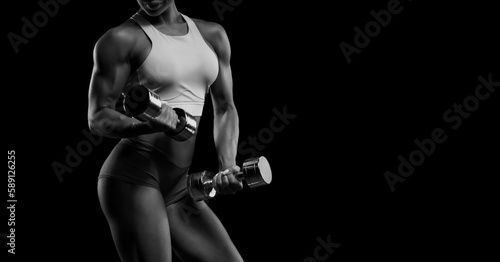 Black and white image of a sports girl on a black background. Fitness concept.