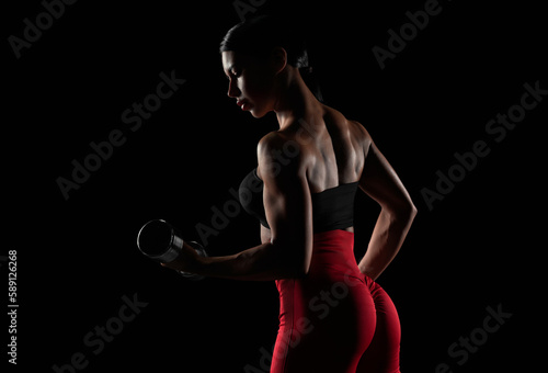 Brutal sports woman pumps up muscles with dumbbells. Fitness concept. © andy_gin