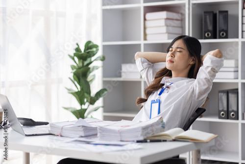 Asian women are stressed or has sore throat at office while working on laptop, Tired asian businesswoman with headache at office, feeling sick at work, copy space © David