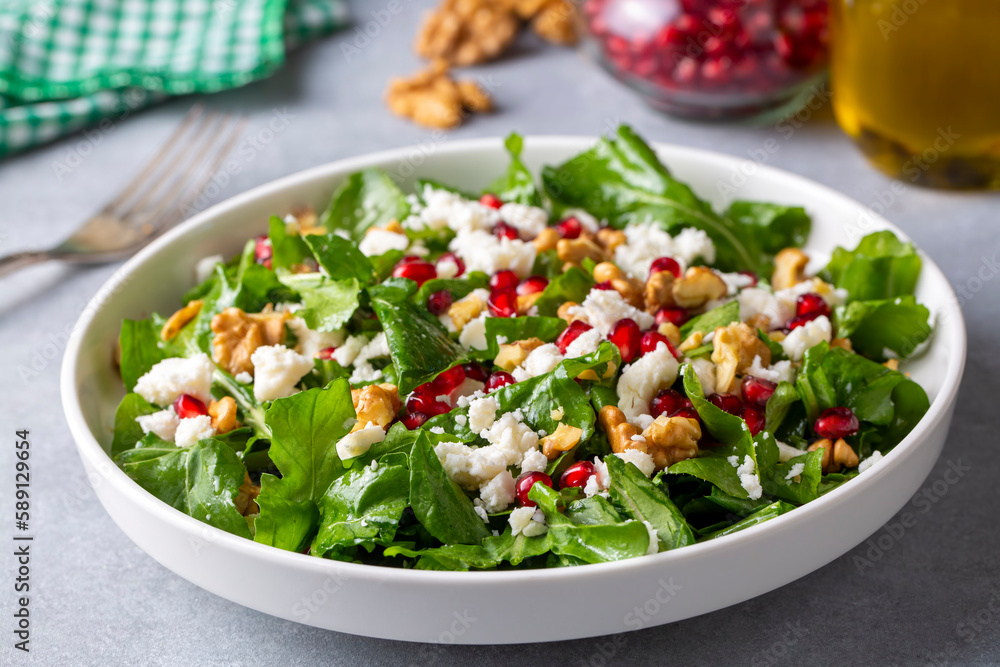 Arugula salad with cheese served with walnuts and pomegranate. Turkish name; Roka salatasi Arugula salad with cheese served with walnuts and pomegranate. Turkish name; Roka salatasi