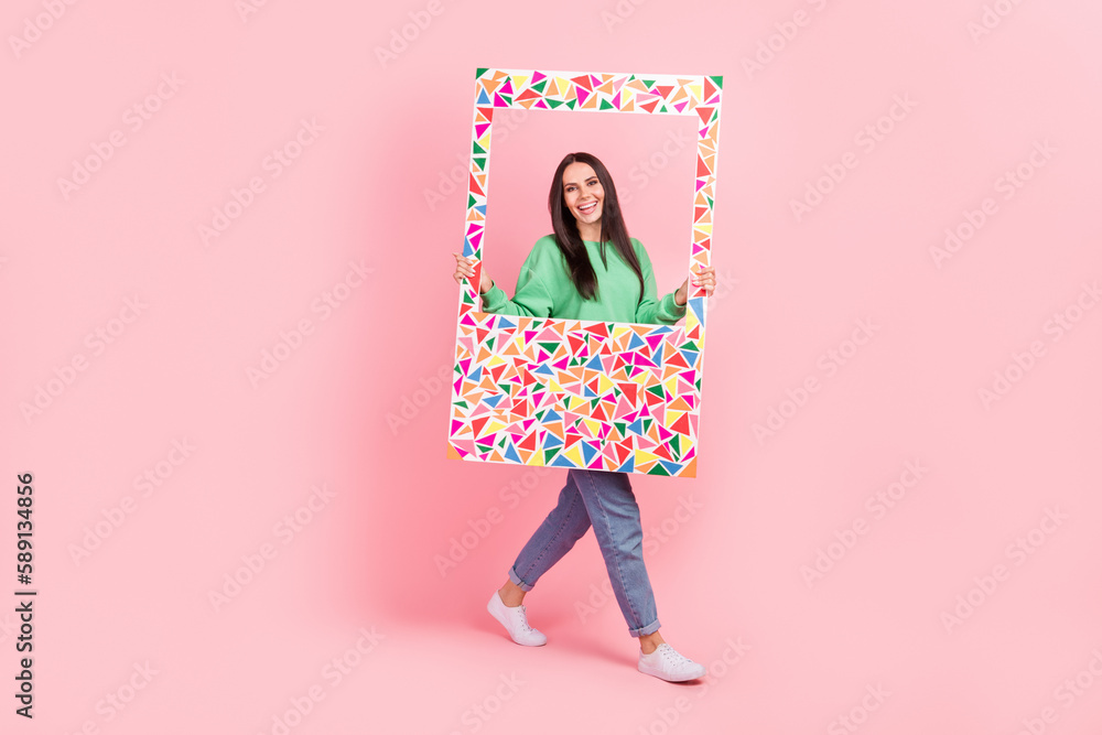 Full length photo of adorable positive lady wear bright green clothes hold big paper moving empty space isolated on pink color background