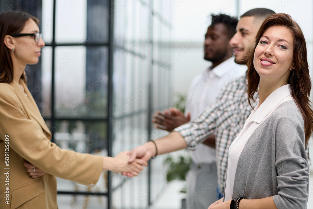 ambitious business woman smiling at the camera against the backdrop of a meeting of colleagues ambitious business woman smiling at the camera against the backdrop of a meeting of colleagues