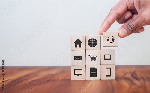 Omnichannel marketing concept. Digital online marketing commerce sale. For customer engagement by integrated online and offline channels. Hand holds wooden cube with omni text standing with omni icon photo