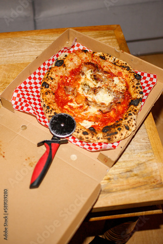 Delicious pizza with tomatoes and cheese in box photo