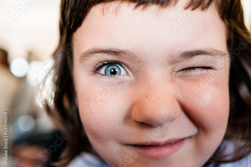 Cute girl winking at camera on blurred background