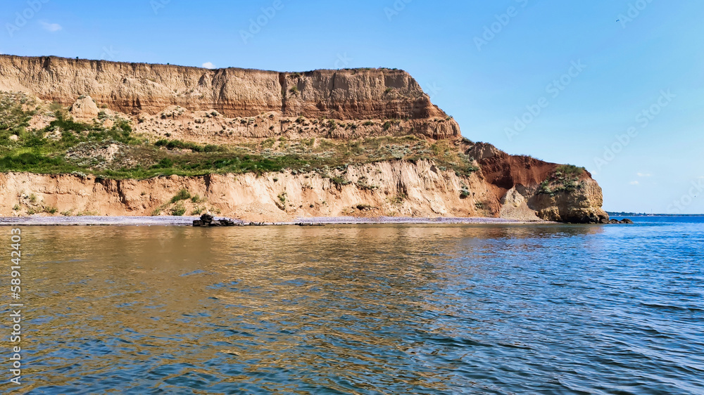 View of the Black Sea and colorful clay cliffs with green grass near Koblevo. Ukraine. Europe	