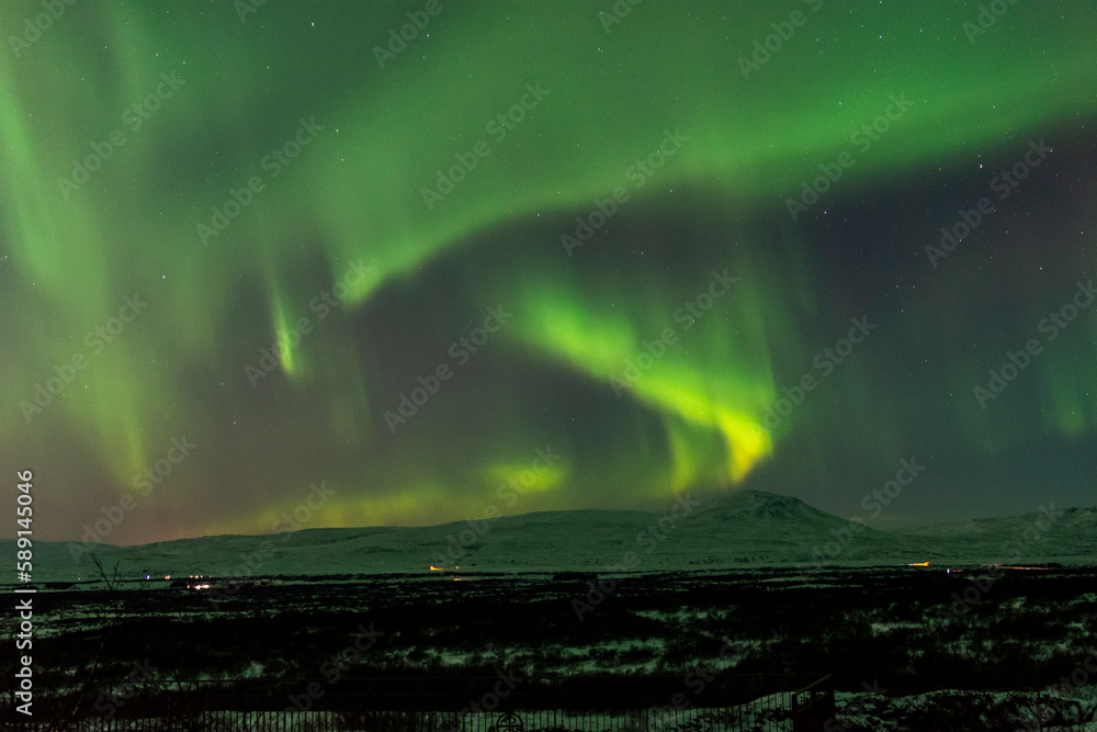 imagen de un paisaje nocturno nevado con una aurora boreal en el cielo de Islandia
