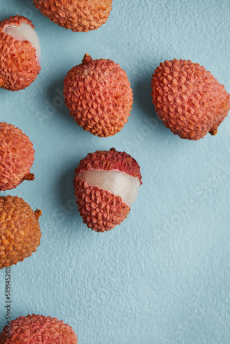 Fresh and cut open ripe lychee fruit on smooth surface