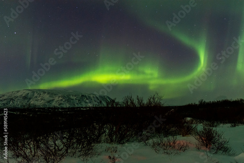 imagen de un paisaje nocturno nevado con una aurora boreal en el cielo de Islandia