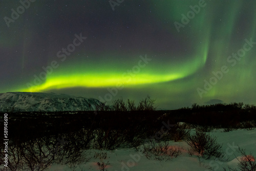 imagen de un paisaje nocturno nevado con una aurora boreal en el cielo de Islandia