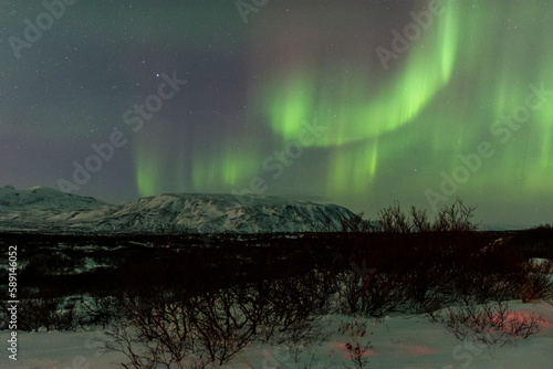 imagen de un paisaje nocturno nevado con una aurora boreal en el cielo de Islandia