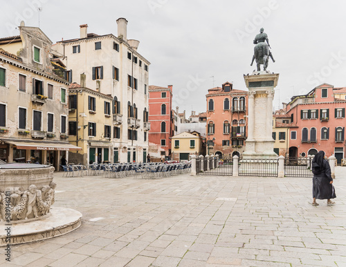 Piazza in Venice Italy with statue and nun walking by