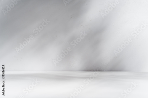Mock up for presentation, branding products, cosmetics, food or jewellery. Empty table on white wall background. Composition with leaves shadow on the wall and white desk.	