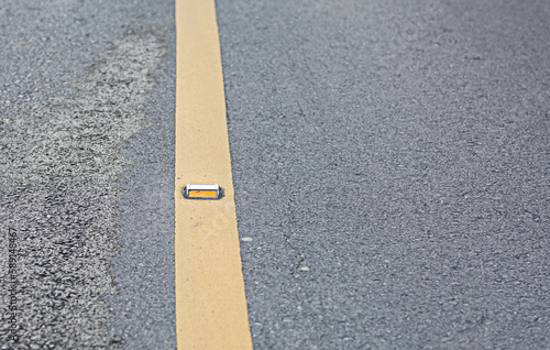 The road stud is installed on the yellow traffic line.