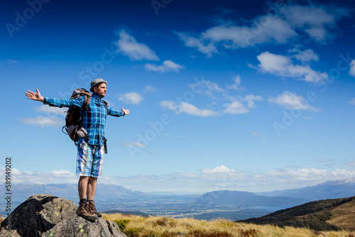 Successful hiker observing on mountain peak cliff edge. New Zealand © olyphotostories