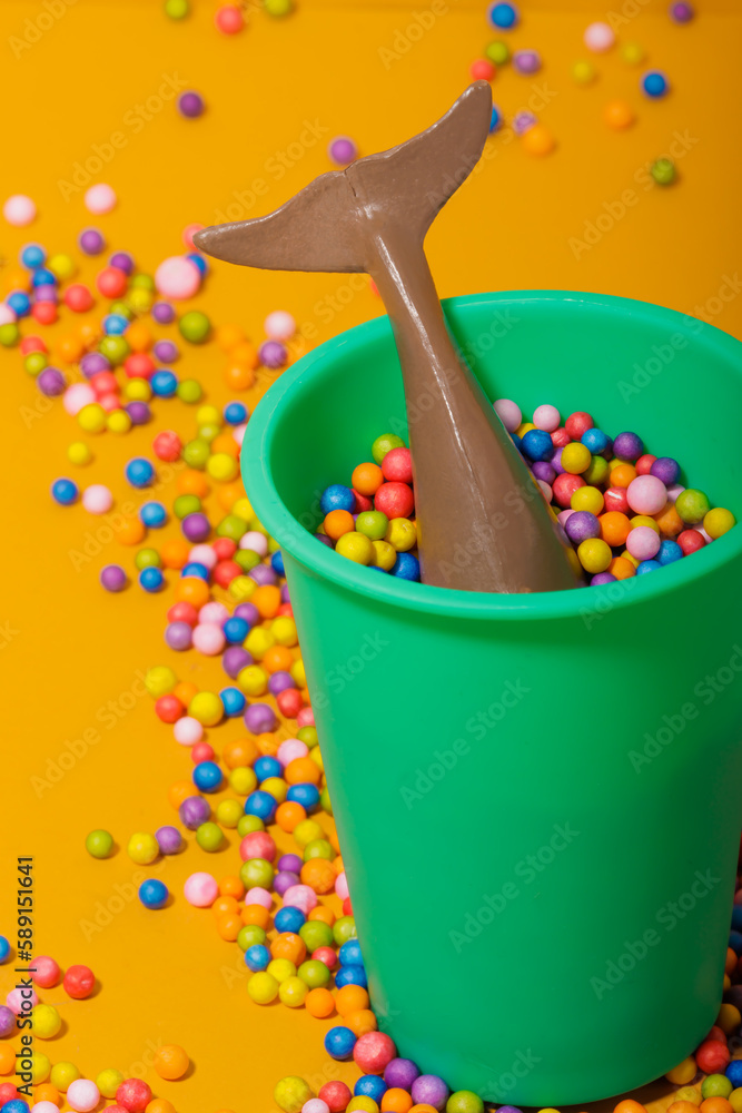 Plastic dolphin in bucket with colorful beads Plastic dolphin in bucket with colorful beads
