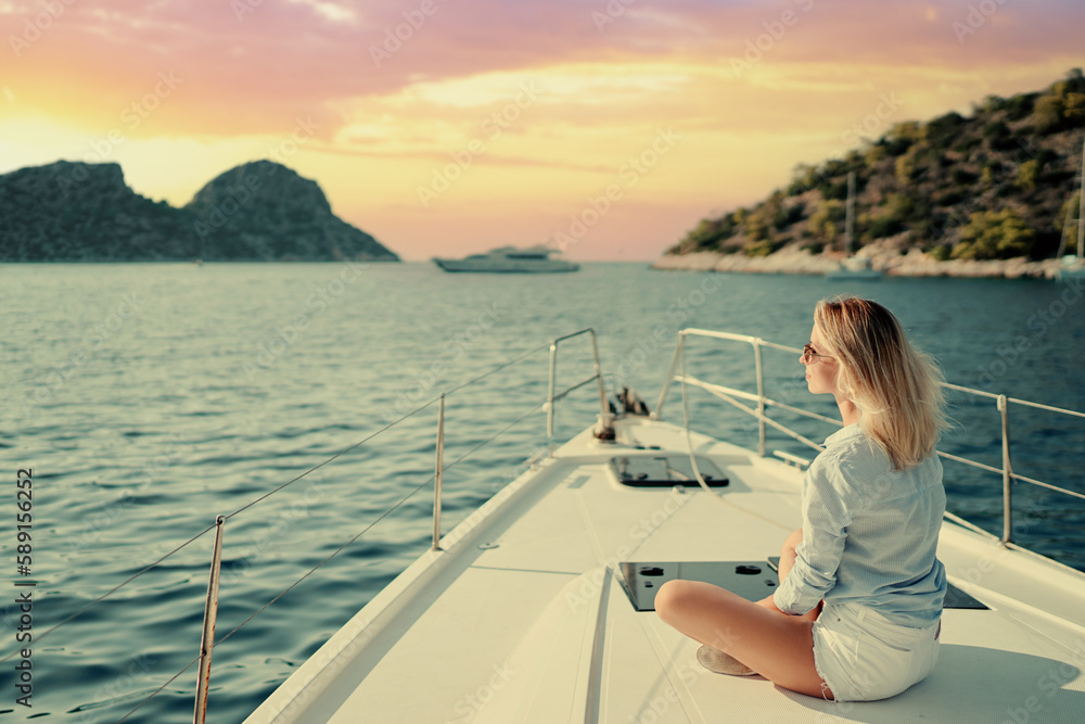 Obraz premium Luxury travel on the yacht. Young happy woman on boat deck sailing the sea. Yachting in Greece.