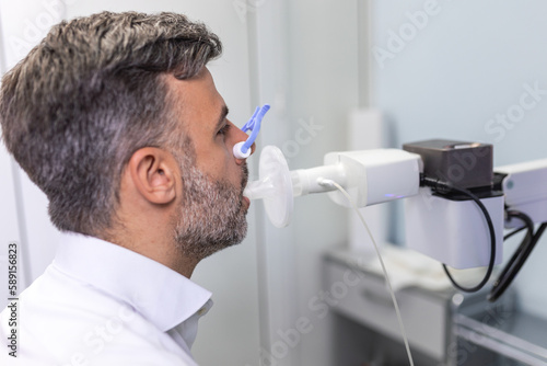Tableau sur toile Man testing breathing function by spirometry