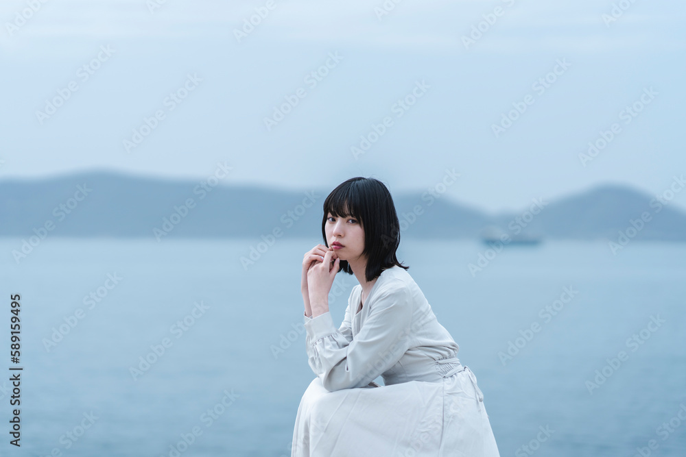 夕暮れの海にいる女性