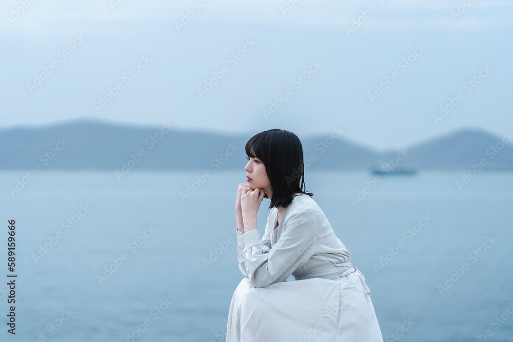 夕暮れの海にいる女性