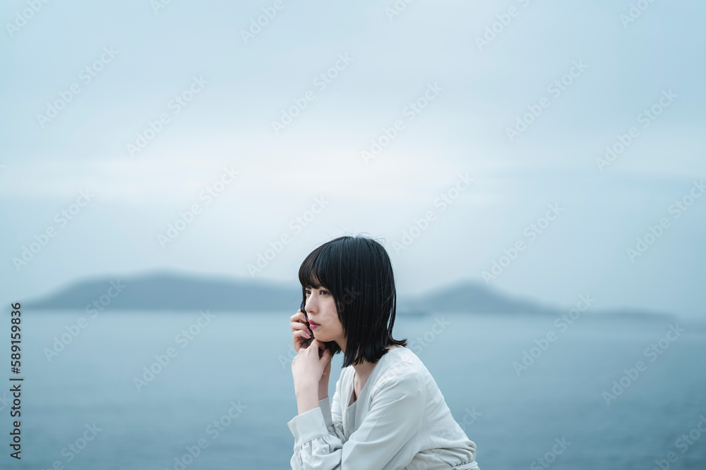 夕暮れの海にいる女性