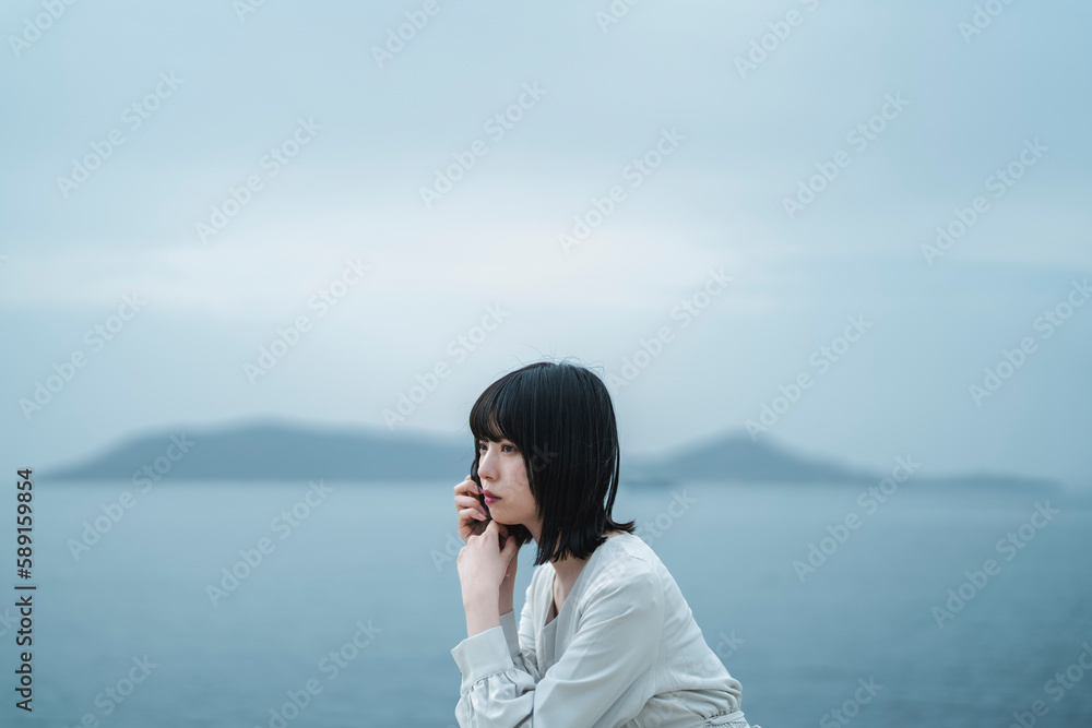 夕暮れの海にいる女性