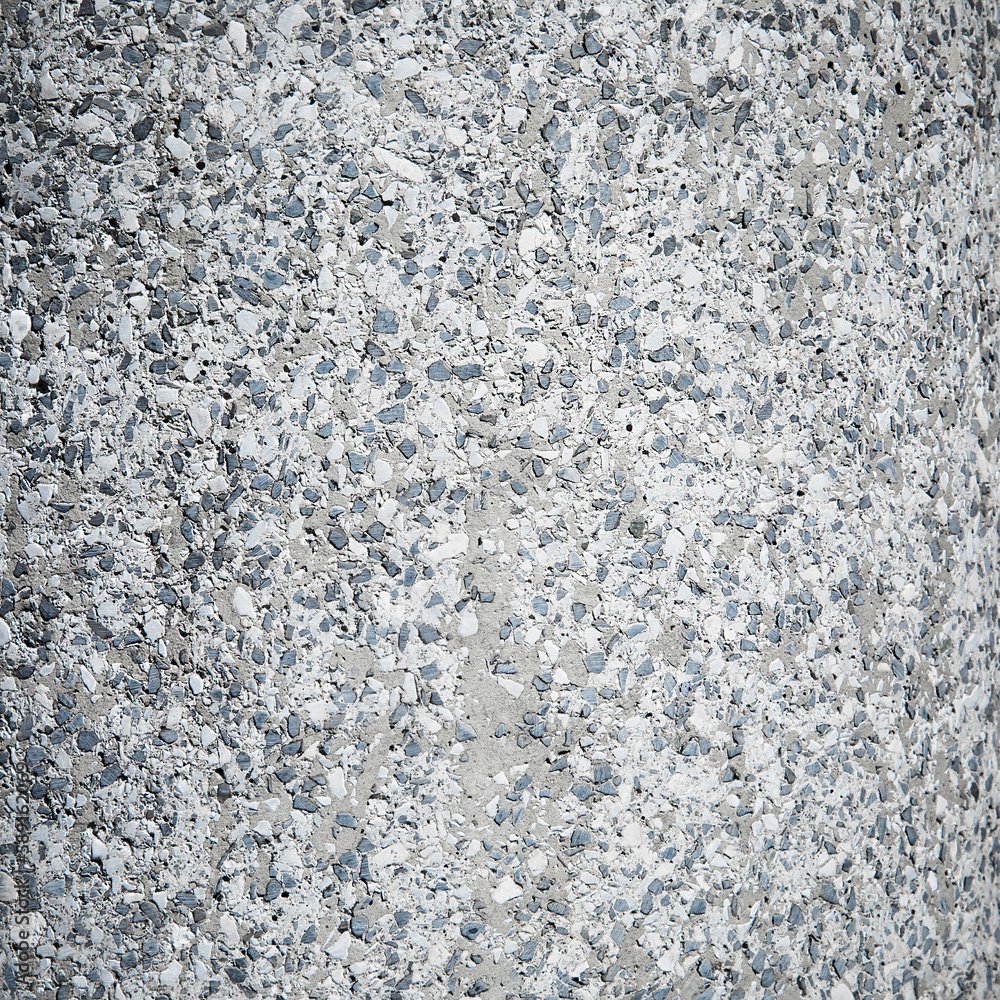 A texture of small stones in a gray-blue tone, the old rough wall of a thick column in the street. Random pattern A texture of small stones in a gray-blue tone, the old rough wall of a thick column in the street. Random pattern