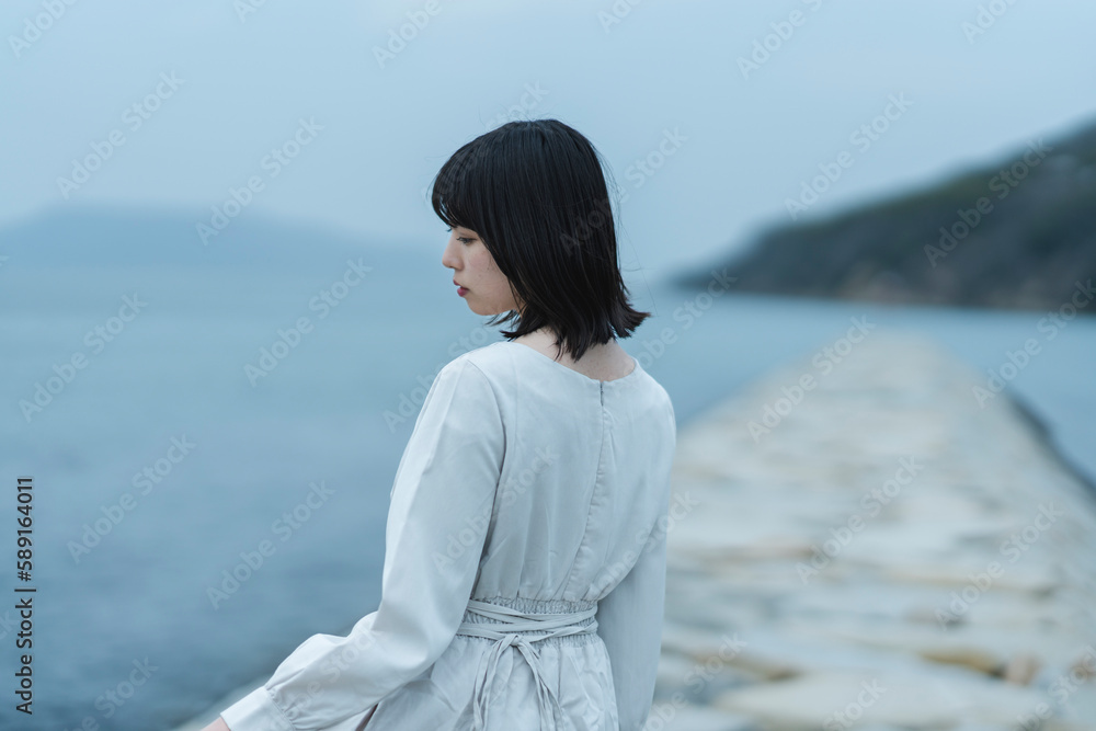 夕暮れの海にいる女性