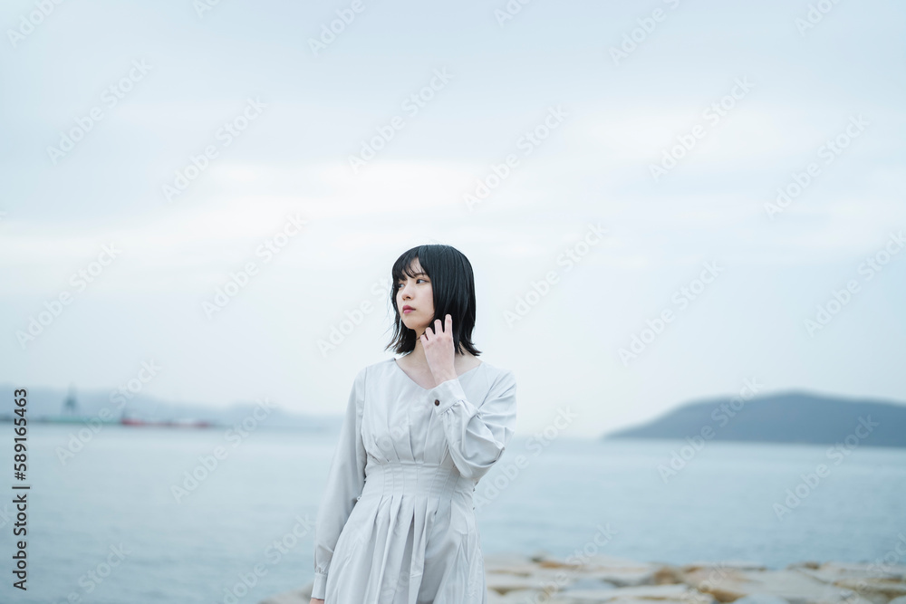 夕暮れの海にいる女性