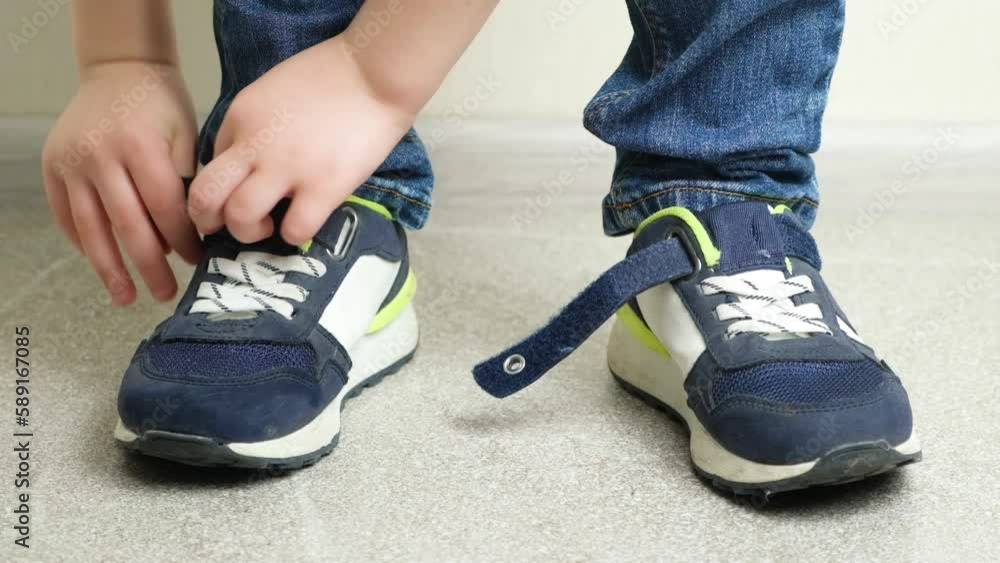 Preschool boy fastening Velcro on sneakers, independent child dress himself Preschool boy fastening Velcro on sneakers, independent child dress himself